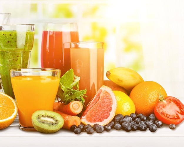 Saborosas frutas e suco com vitaminas no fundo