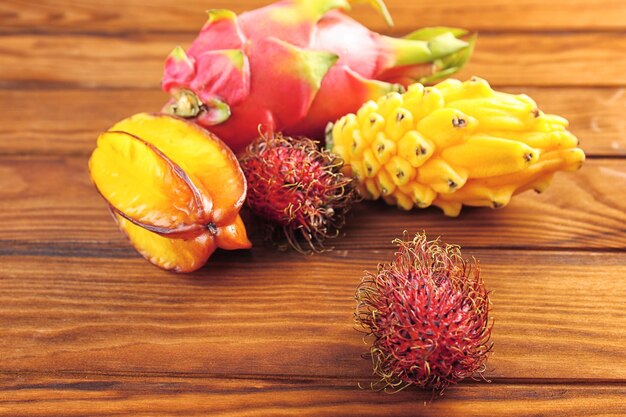 Saborosas frutas exóticas em fundo de madeira