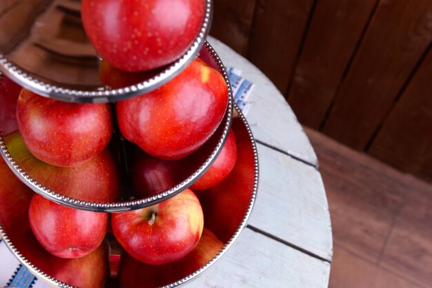 Saborosas maçãs maduras na bandeja na mesa close-up