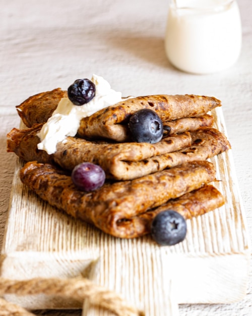 Saborosas panquecas de chocolate caseiras com creme de leite e mirtilo