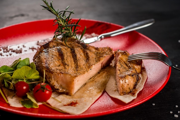 Saboroso bife de mármore grelhado fresco em uma placa vermelha