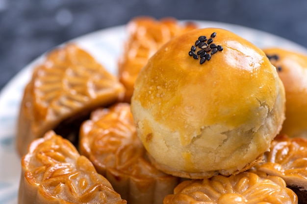 Saboroso bolo de folha de gema de ovo cozido lua para Mid-Autumn Festival em fundo escuro de ardósia preta. Conceito de comida festiva chinesa, close-up, copie o espaço.