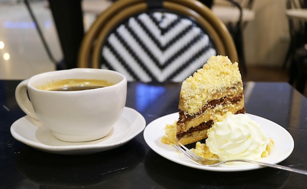 Saboroso bolo de torta de banoffee com uma xícara de café preto servido na mesa