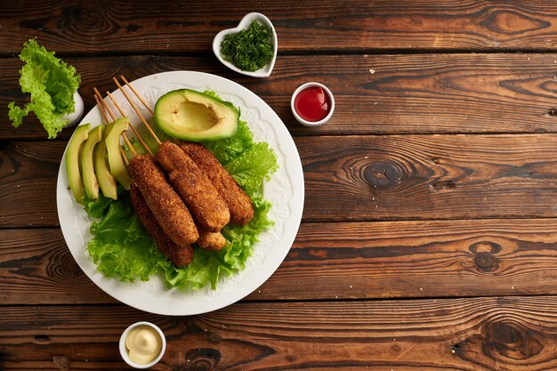 Saboroso cachorro-quente com molho e salada servido em prato branco na mesa de madeira