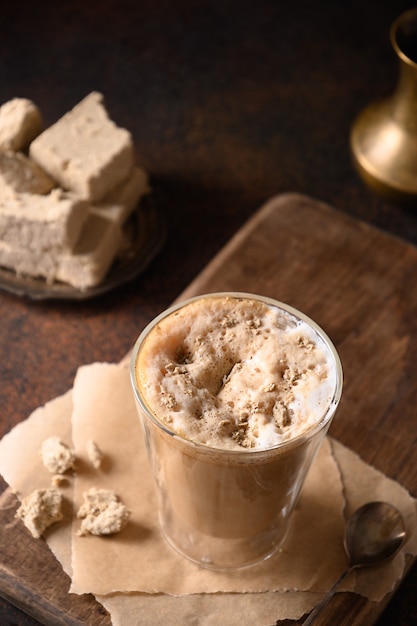 Saboroso café com leite com halva em copo de vidro.