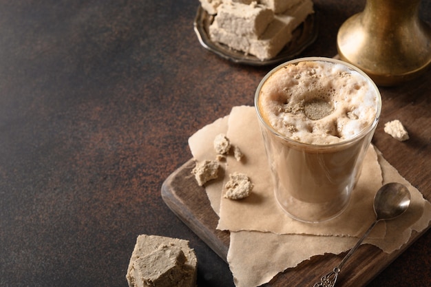 Saboroso café com leite com halva em copo de vidro