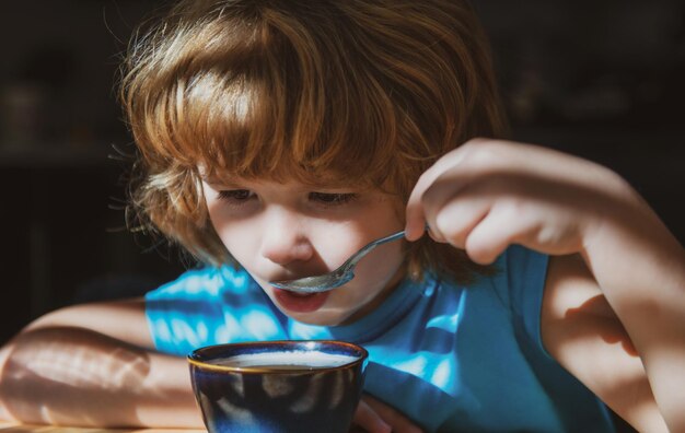 Saboroso café da manhã infantil comida caseira saudável menino come na cozinha nutrição para crianças