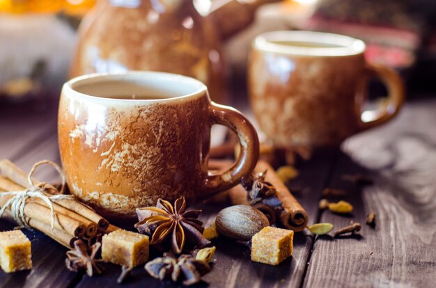 Saboroso café quente com grãos e especiarias na mesa