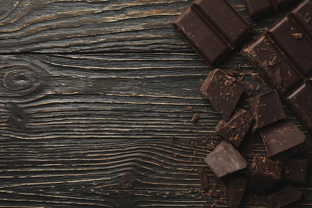 Saboroso chocolate com fundo de madeira, vista superior