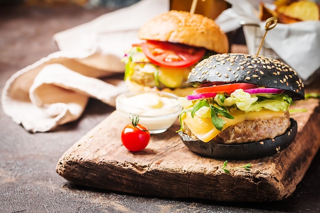Saboroso hambúrguer clássico de carne preta grelhada com molho de alface e maionese em mesa de madeira rústica, com espaço de cópia
