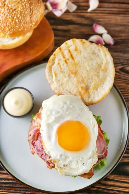 Saboroso hambúrguer com bacon e ovo frito na mesa