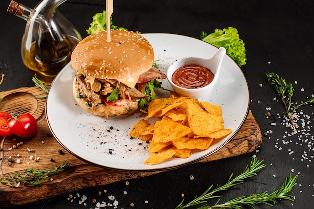 Saboroso hambúrguer fresco com carne comprada e batatas fritas em fundo de madeira