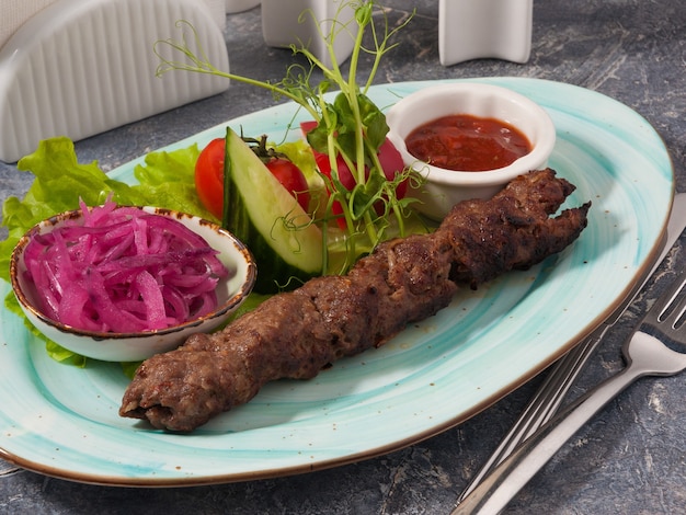 Saboroso kebab de vitela Lula com molho de tomate, cebola e legumes