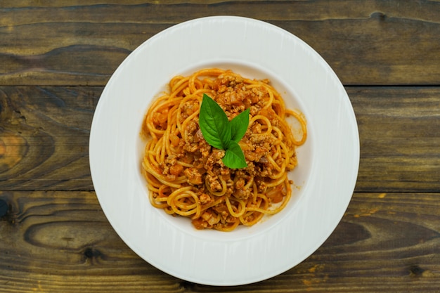 Saboroso macarrão espaguete italiano clássico apetitoso com molho de tomate e manjericão na placa