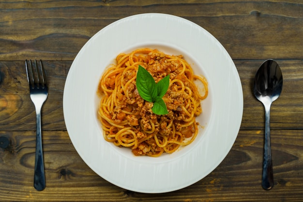 Saboroso macarrão espaguete italiano clássico apetitoso com molho de tomate e manjericão na placa