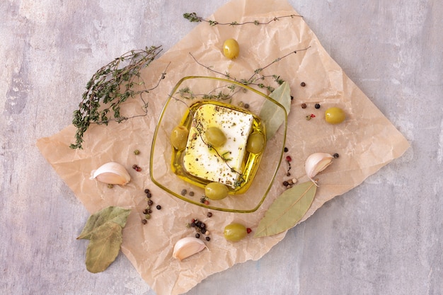 Saboroso queijo feta com azeitonas, azeite e especiarias na superfície cinzenta