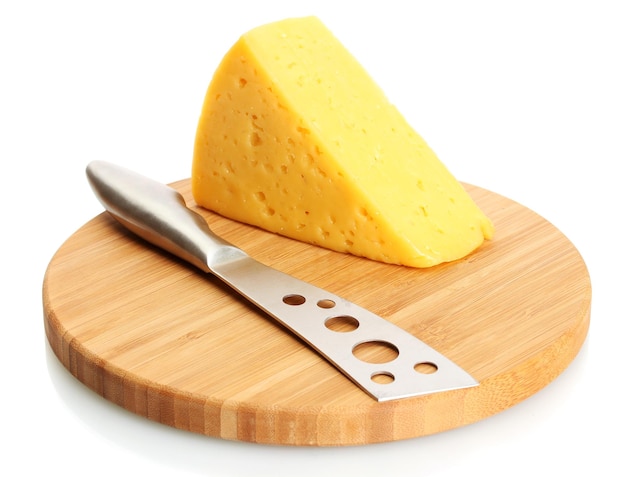 Saboroso queso y cuchillo en una tabla de cortar de madera aislada en blanco