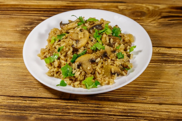 Saboroso risoto com cogumelos na mesa de madeira