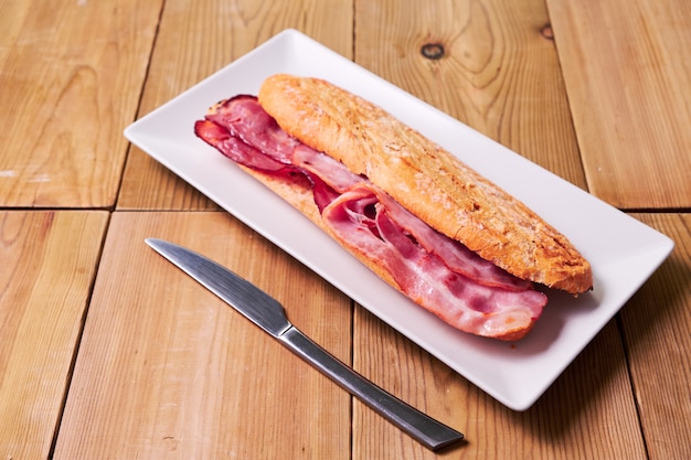 Saboroso sanduíche feito de baguete crocante e bacon