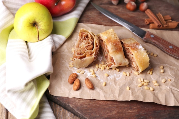 Saboroso strudel de maçã caseiro em guardanapo de papel, em superfície de madeira