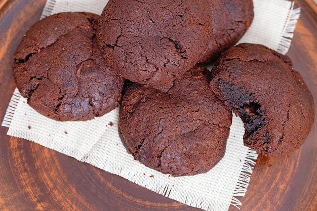 Saborosos biscoitos de chocolate redondos em prato de barro