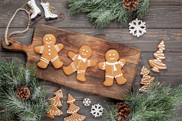 Saborosos biscoitos de gengibre e uma decoração de Natal em fundo de madeira.