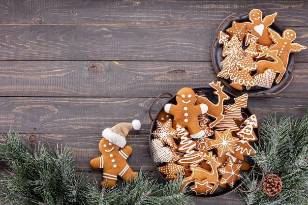 Saborosos biscoitos de gengibre e uma decoração de Natal em fundo de madeira.