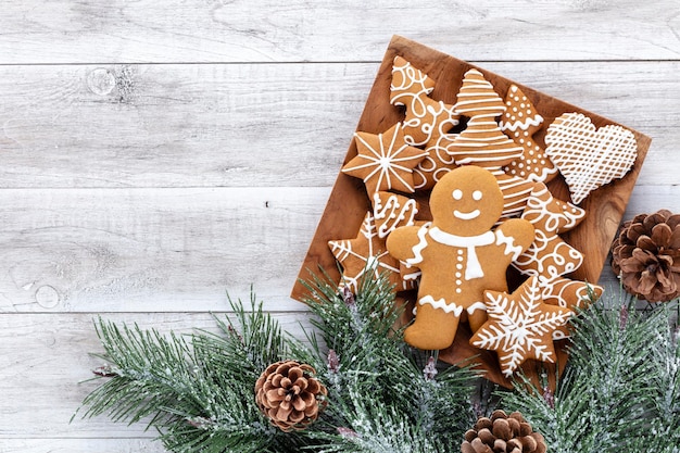 Saborosos biscoitos de gengibre e uma decoração de Natal em fundo de madeira.