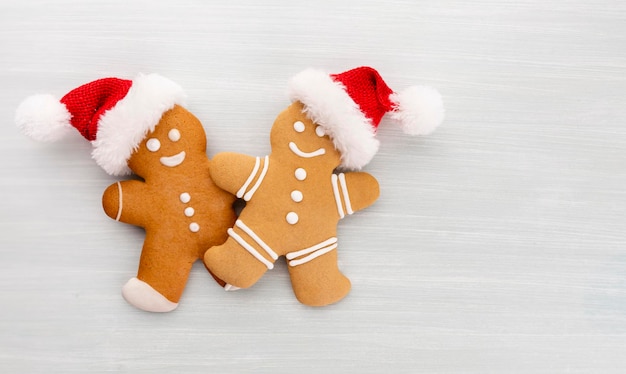 Saborosos biscoitos de gengibre e uma decoração de Natal em fundo pastel.