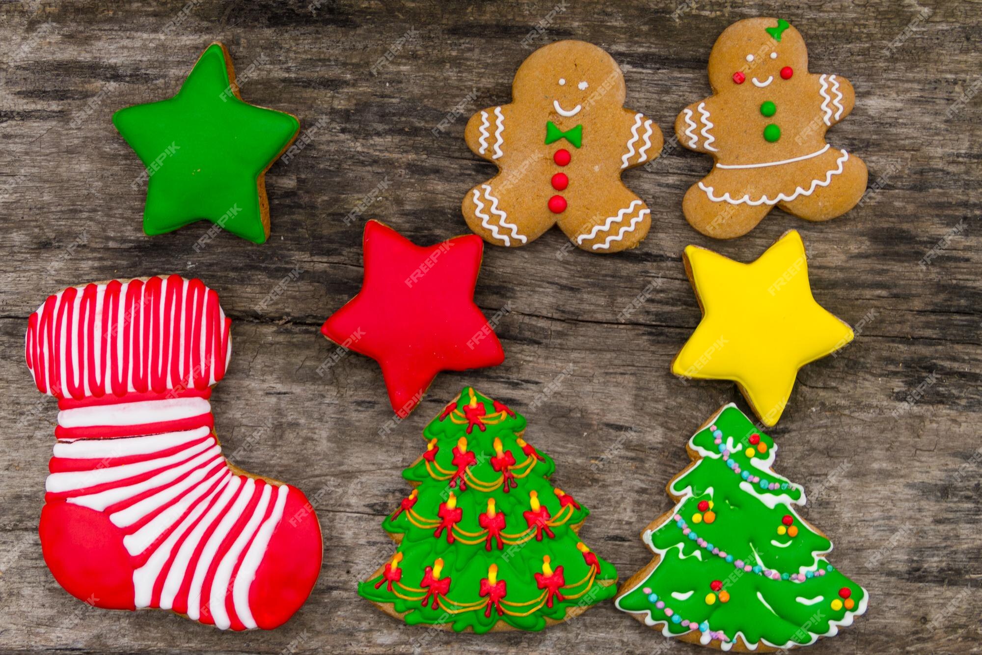 Saborosos biscoitos de natal festivos em forma de árvore de natal, homem- biscoito, estrela e meia de natal na mesa de madeira rústica. vista do topo  | Foto Premium