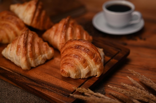 Saborosos croissants amanteigados na mesa de madeira preta com café quente Levitação pão produtos de padaria conceito de café