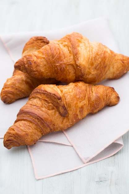 Saborosos croissants amanteigados na velha mesa de madeira.