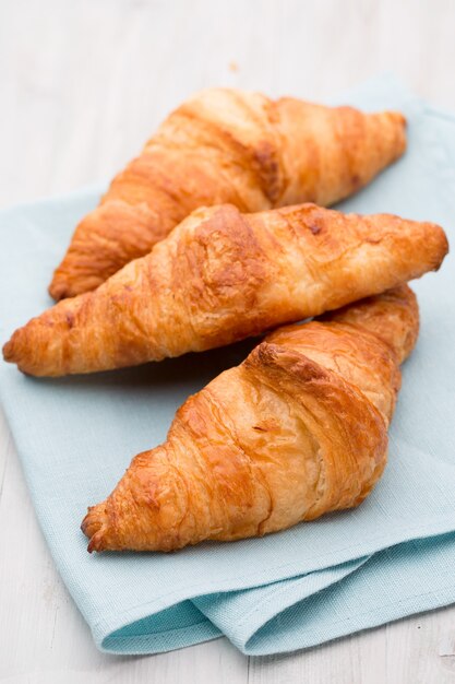 Saborosos croissants amanteigados na velha mesa de madeira.