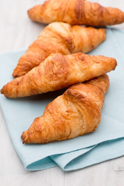 Saborosos croissants amanteigados na velha mesa de madeira.