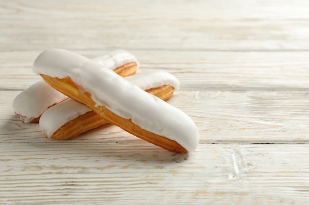 Saborosos éclairs com creme em fundo de madeira