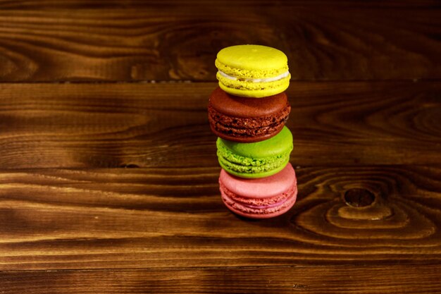 Saborosos macaroons coloridos na mesa de madeira