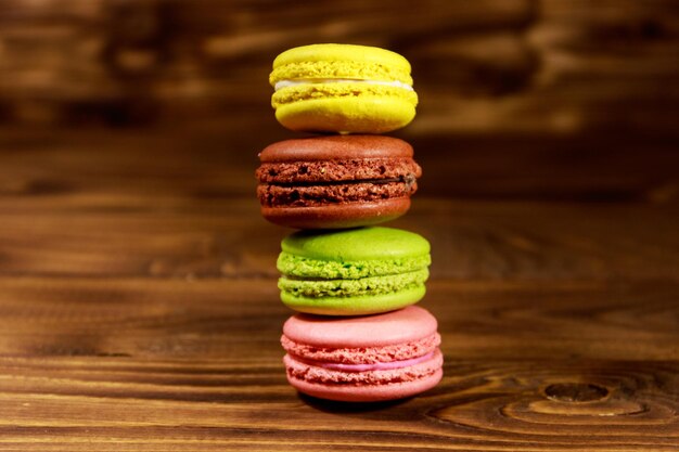 Saborosos macaroons coloridos na mesa de madeira