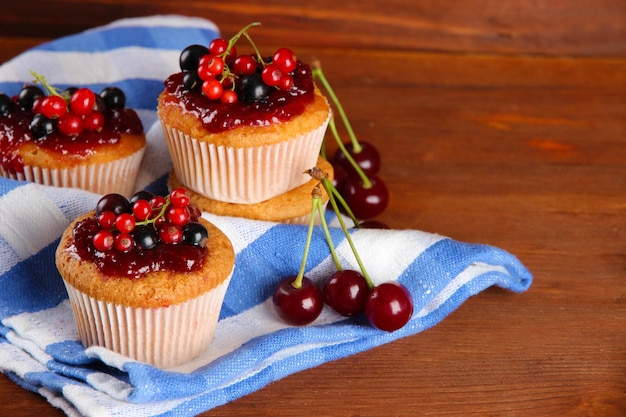 Saborosos muffins com frutas na mesa de madeira