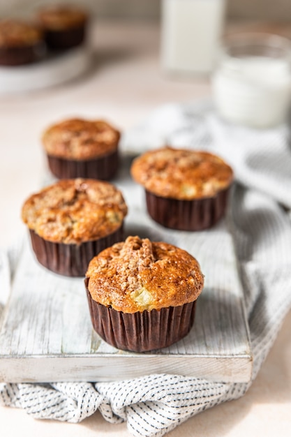 Saborosos muffins de café da manhã com migalhas de aveia cobrindo a superfície de concreto leve da placa de corte branca