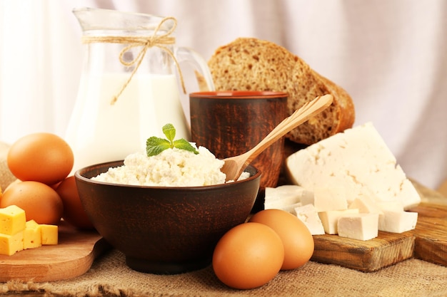 Saborosos produtos lácteos com pão na mesa sobre fundo claro