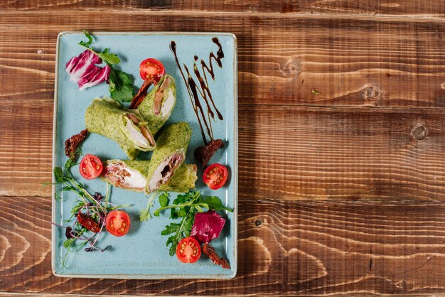 Saborosos rolos verdes cheios de salmão e queijo em fundo de madeira