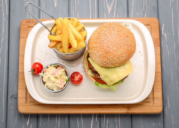 Sabrosa y apetitosa hamburguesa con queso. En una mesa de madera