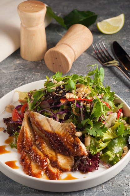 Sabrosa cocina japonesa Ensalada de algas chuka y anguila ahumada Unagi con salsa de nueces cubierta con salsa de anguila y sésamo