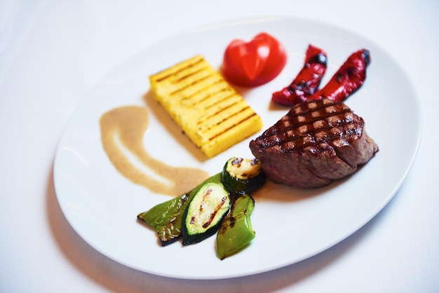 sabrosa comida de carne a la barbacoa, jugoso filete de ternera con queso a la parrilla y ensalada en el restaurante