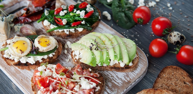 Sabrosa y deliciosa bruschetta con tomate, espinacas, aguacate feta, ají rojo y queso azul.