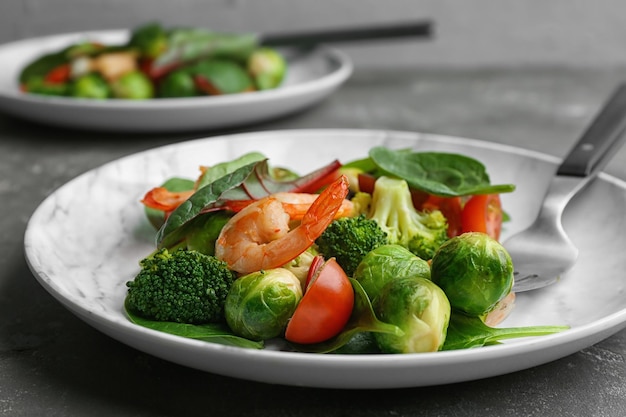 Sabrosa ensalada con coles de Bruselas en el primer plano de la mesa gris