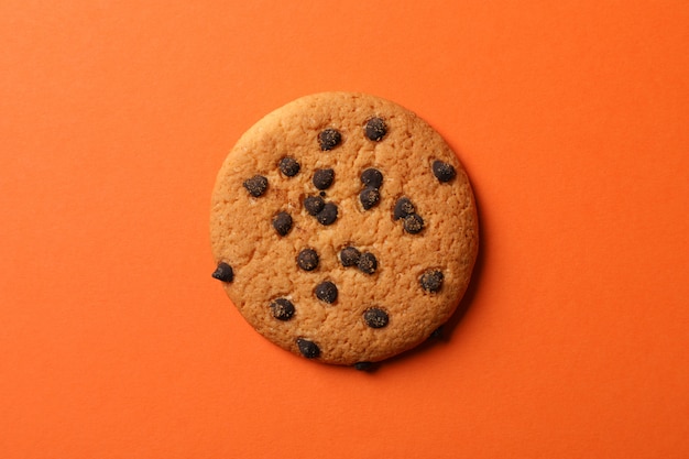 Sabrosa galleta con chispas de chocolate sobre fondo naranja