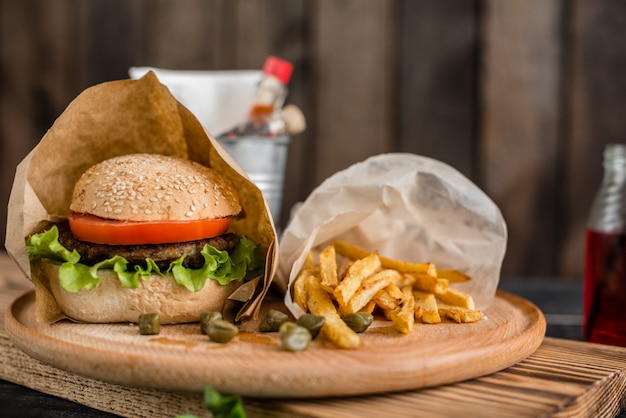 Sabrosa hamburguesa con carne y verduras sobre un fondo oscuro. Comida rápida. Se puede utilizar como fondo.