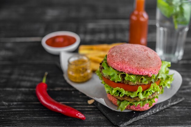 Sabrosa hamburguesa con carne y verduras sobre un fondo oscuro. Comida rápida. Se puede utilizar como fondo.