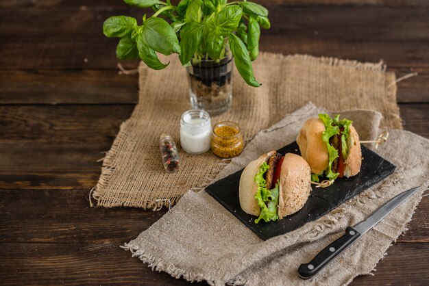 Sabrosa hamburguesa con carne y verduras sobre un fondo oscuro